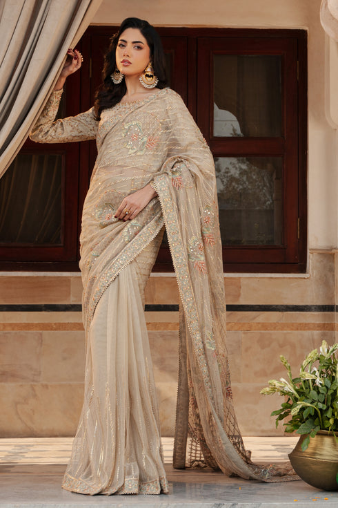 Side profile of NAQSHI Ramish saree highlighting flowy net pallu with embroidered floral motifs and fitted blouse silhouette in skin tone