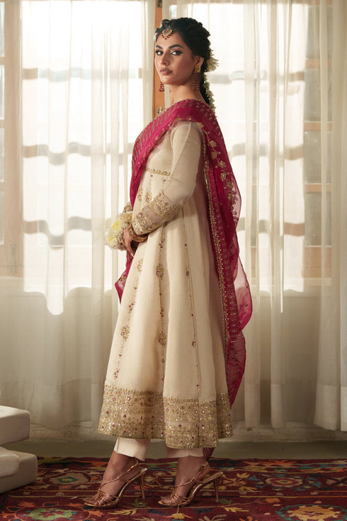 Side profile of NAQSHI Rumi showcasing fluid viscose frock cut, tailored sleeves, front slit, and matching PK raw‑silk trouser silhouette