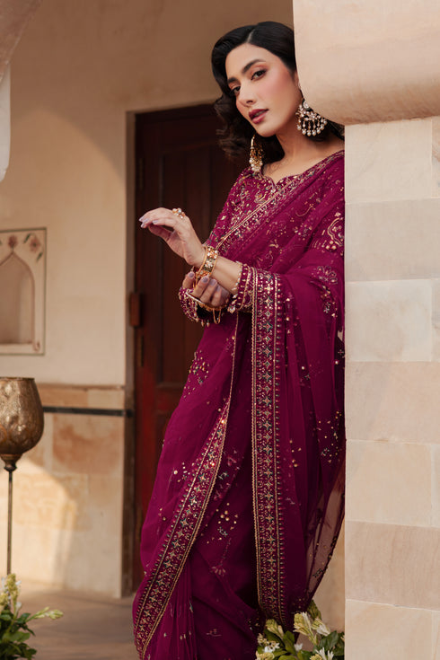 Side view of NAQSHI Meeru highlighting net drape with all‑over embroidered motifs, shimmering work and coordinated burgundy hues in petticoat