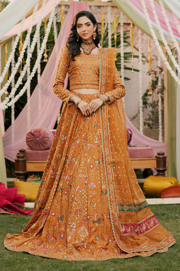 Model styled in full NAQSHI Romanvi 3PC set: tangerine raw‑silk lehenga choli, boat-neck choli, handmade tassels and embroidered organza dupatta
