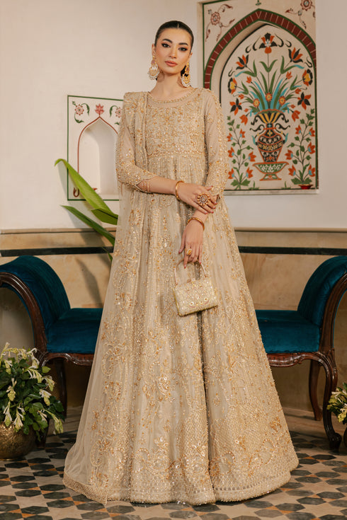 NAQSHI Maneha champagne‑gold net maxi frock with boat neckline, sheer organza appliqué at bodice, heavy pearl & stone embellishments across front