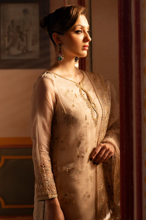 Side view of NAQSHI Shifa beige organza outfit showing layered shirt panels, fitted sleeves, and refined formal silhouette.