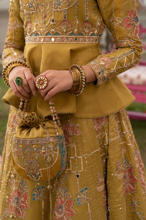 Naqshi Gulnaar raw‑silk pouch adorned with mirror work and hanging tassels matching ensemble theme