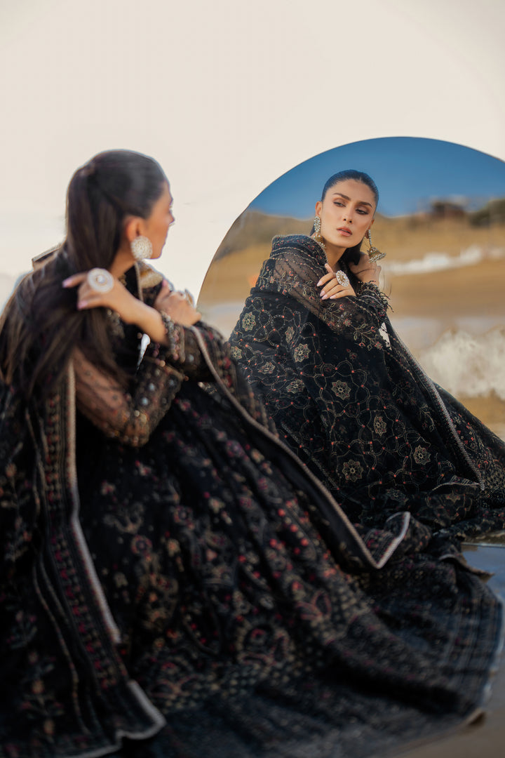 Side view of NAQSHI Blain showcasing fluid frock silhouette, detailed sleeve-end crystal hangings, richly composed embroidered panels, and floor‑length cutline.
