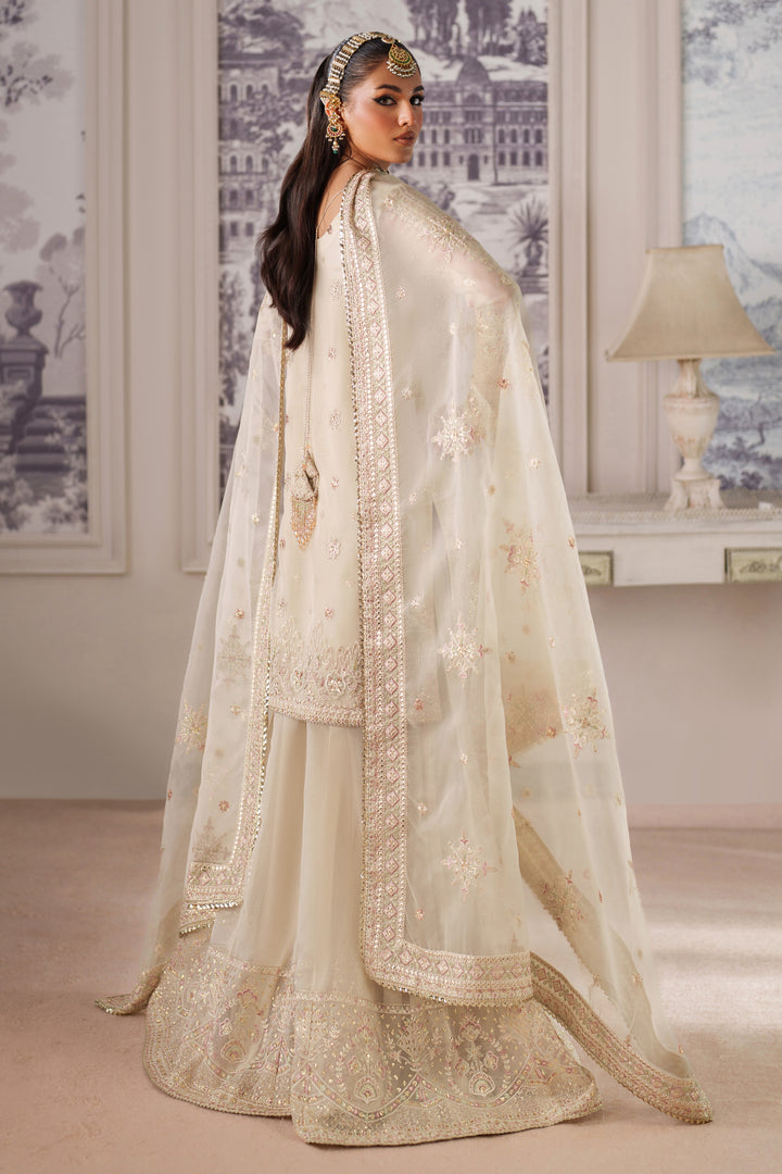 Back view of NAQSHI Seemal cream formal dress with detailed embroidery and flowing dupatta for special occasion wear.