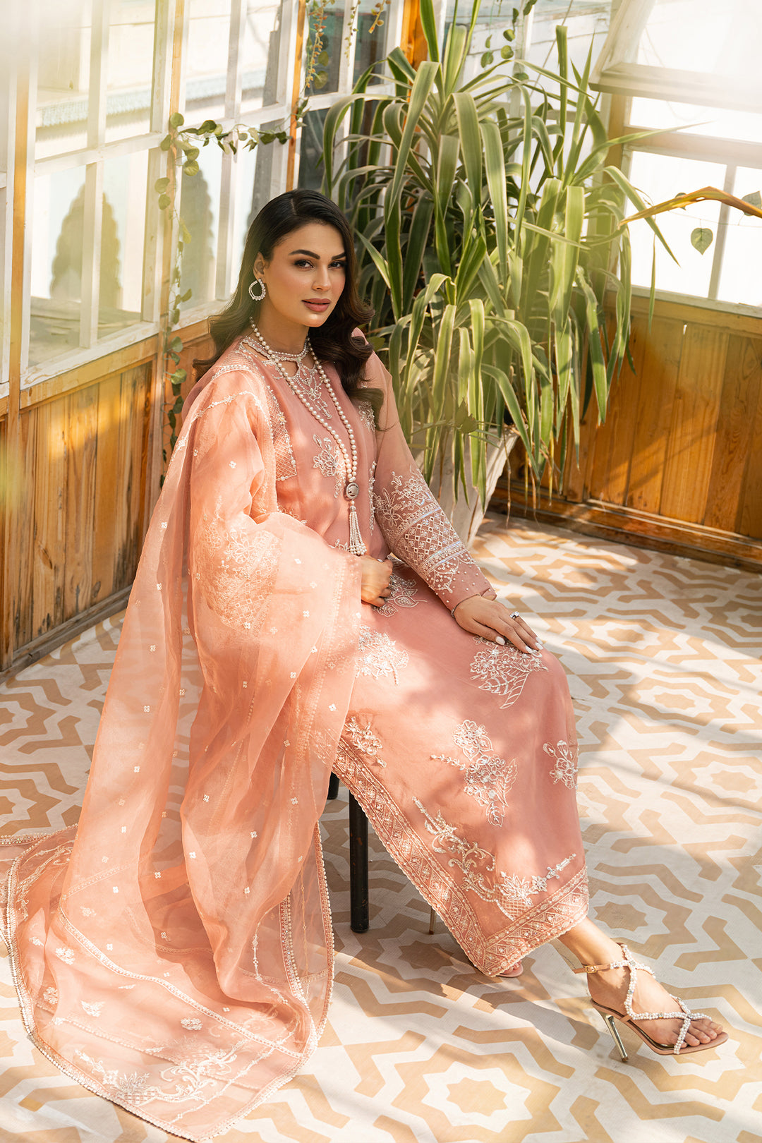 Seated styling look of Ovate ensemble featuring detailed embroidery and light organza layers, formal ready made eastern wear.