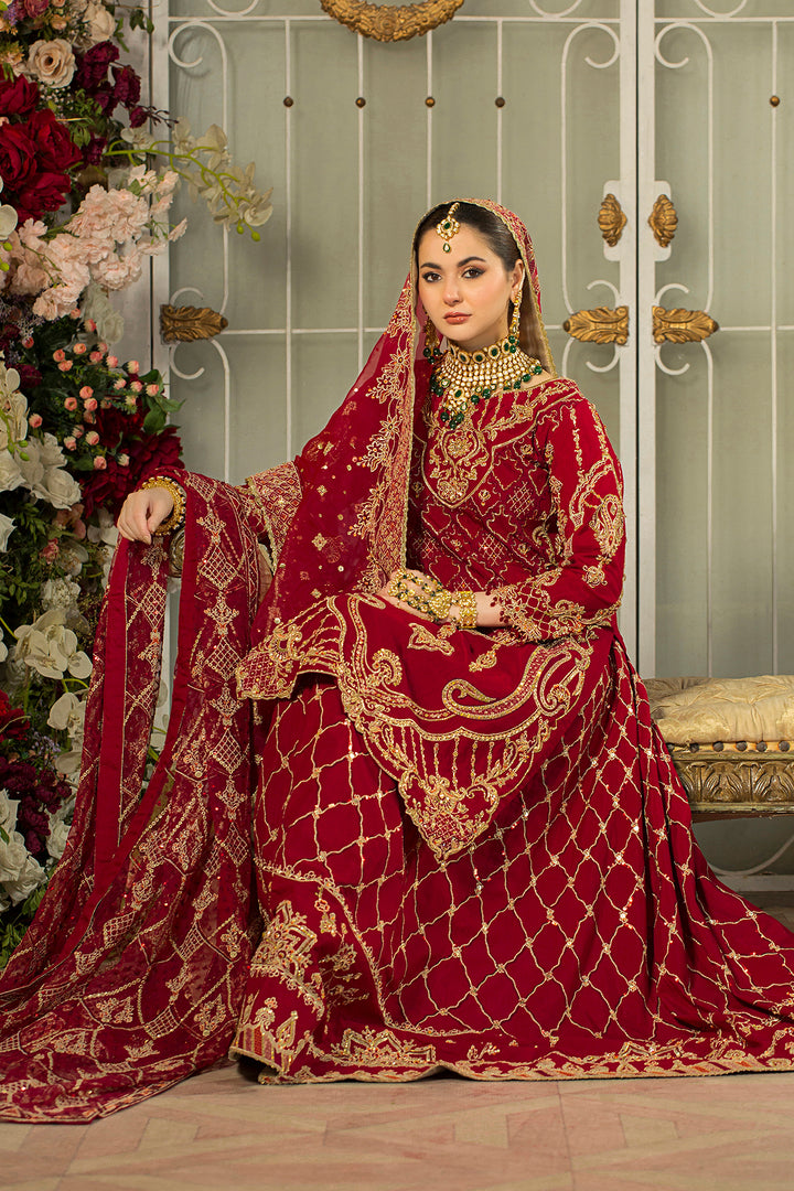 Model wearing full Naqshi Gehna 4PC set: deep-red embroidered shirt, tasselled tail lehenga, matching pouch &amp; ornate dupatta styled for baraat glamour.