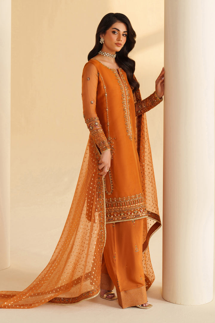 Side view of NAQSHI burnt orange formal dress highlighting flowing dupatta, elegant cut, and polished occasion wear look
