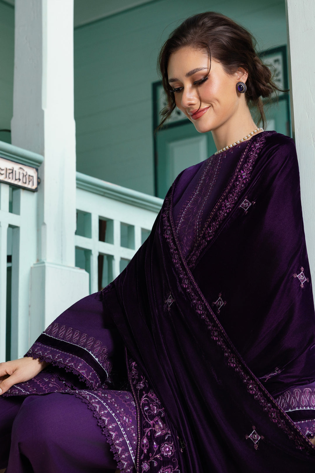 Model wearing NAQSHI Ishana plum khaddar &amp; velvet 3-piece suit with shawl drape.