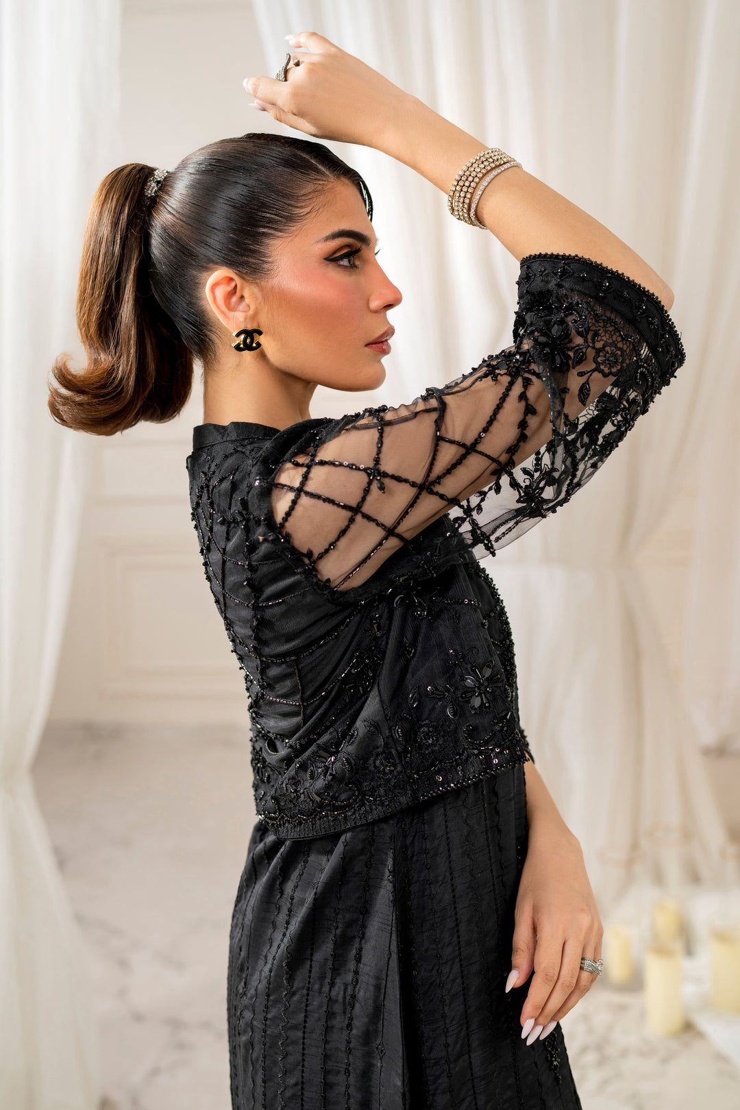Model wearing full naqshi siara 4PC set: embroidered shirt, cropped net jacket with beads, straight pants and sequin dupatta styled for formal play.

