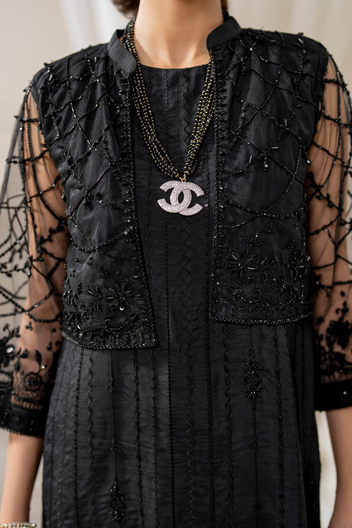 Close-up of naqshi siara cropped jacket sleeve cuff featuring dense net embroidery, crystals, beads &amp; hand‑made hangings.