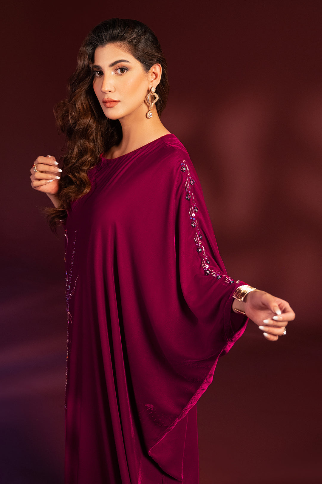 Side angle view of NAQSHI Aelin shocking pink kaftan tunic highlighting fitted sleeve with cuff embellishment