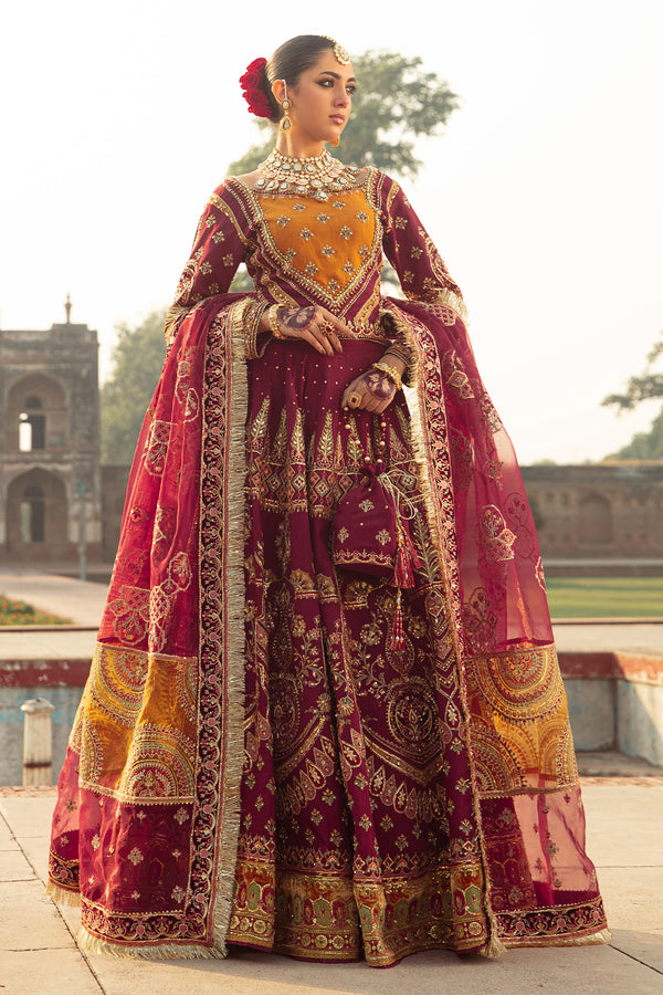 Naqshi Ismat maroon raw‑silk choli with boat neckline, mustard applique and heavy adda embroidery, paired with velvet-hem lehenga and scalloped organza dupatta.

