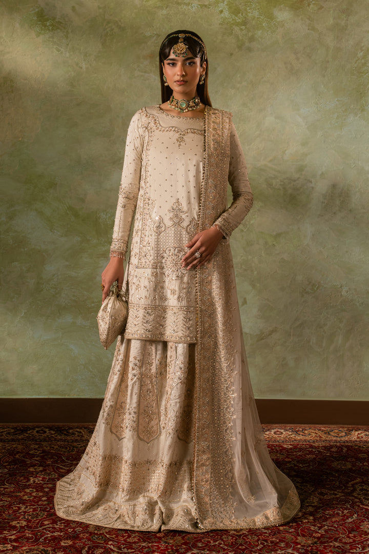 Full standing look of Damiya off white sharara suit highlighting balanced silhouette and clean embroidery detailing, formal ready made Nikkah outfit.