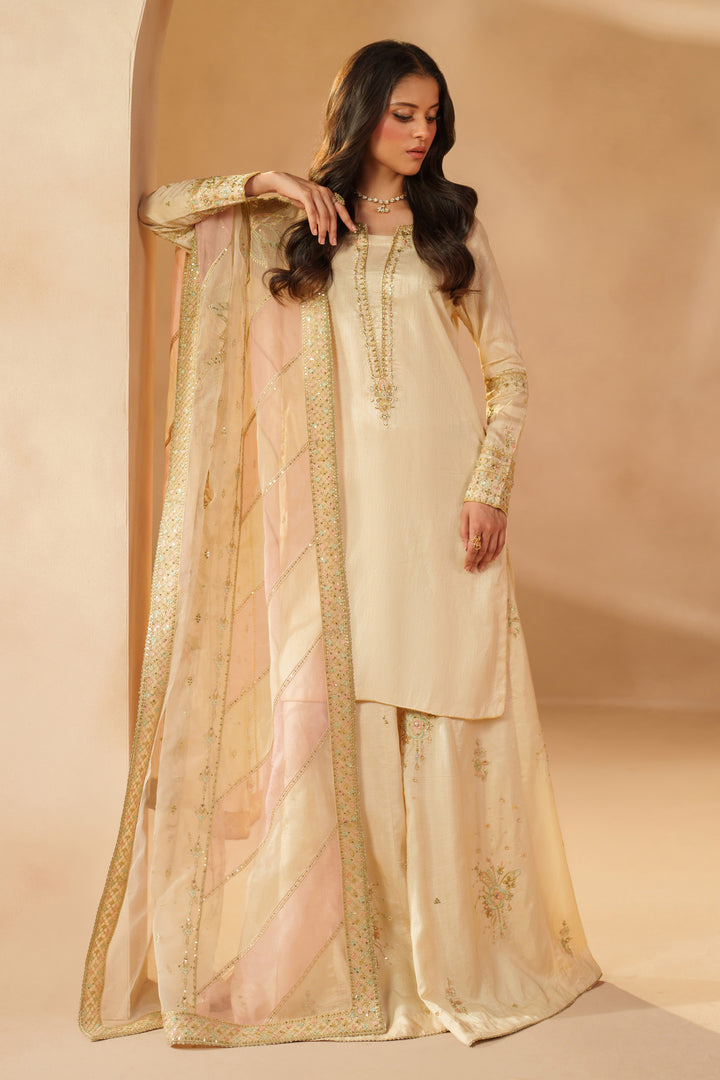 Model wearing NAQSHI Mawrah formal beige sharara set with embroidered shirt and dupatta, ideal ready-to-wear choice for reception, mehndi, or wedding celebrations