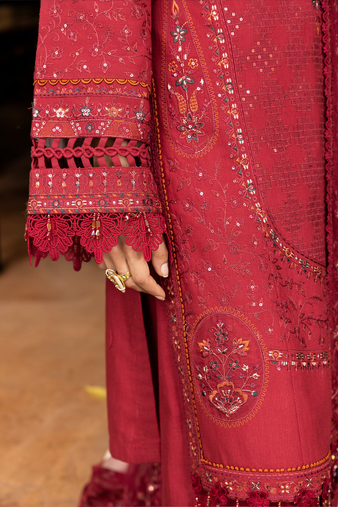 Close-up of a red embroidered garment with intricate patterns.