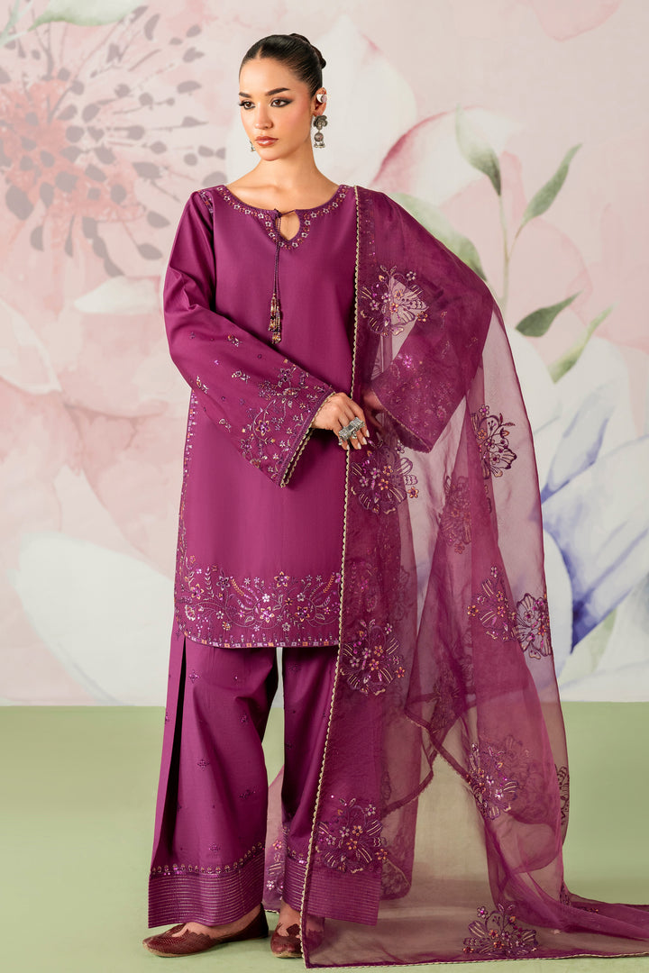 Woman wearing a purple embroidered outfit with a matching dupatta against a floral background