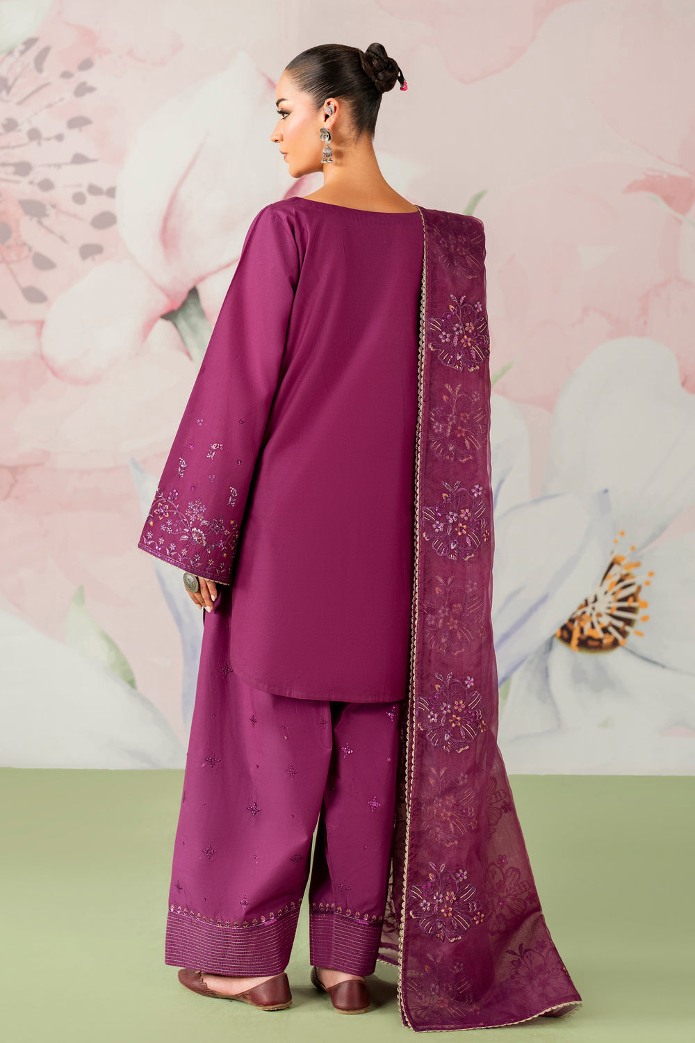 Woman wearing a purple traditional outfit with a floral background