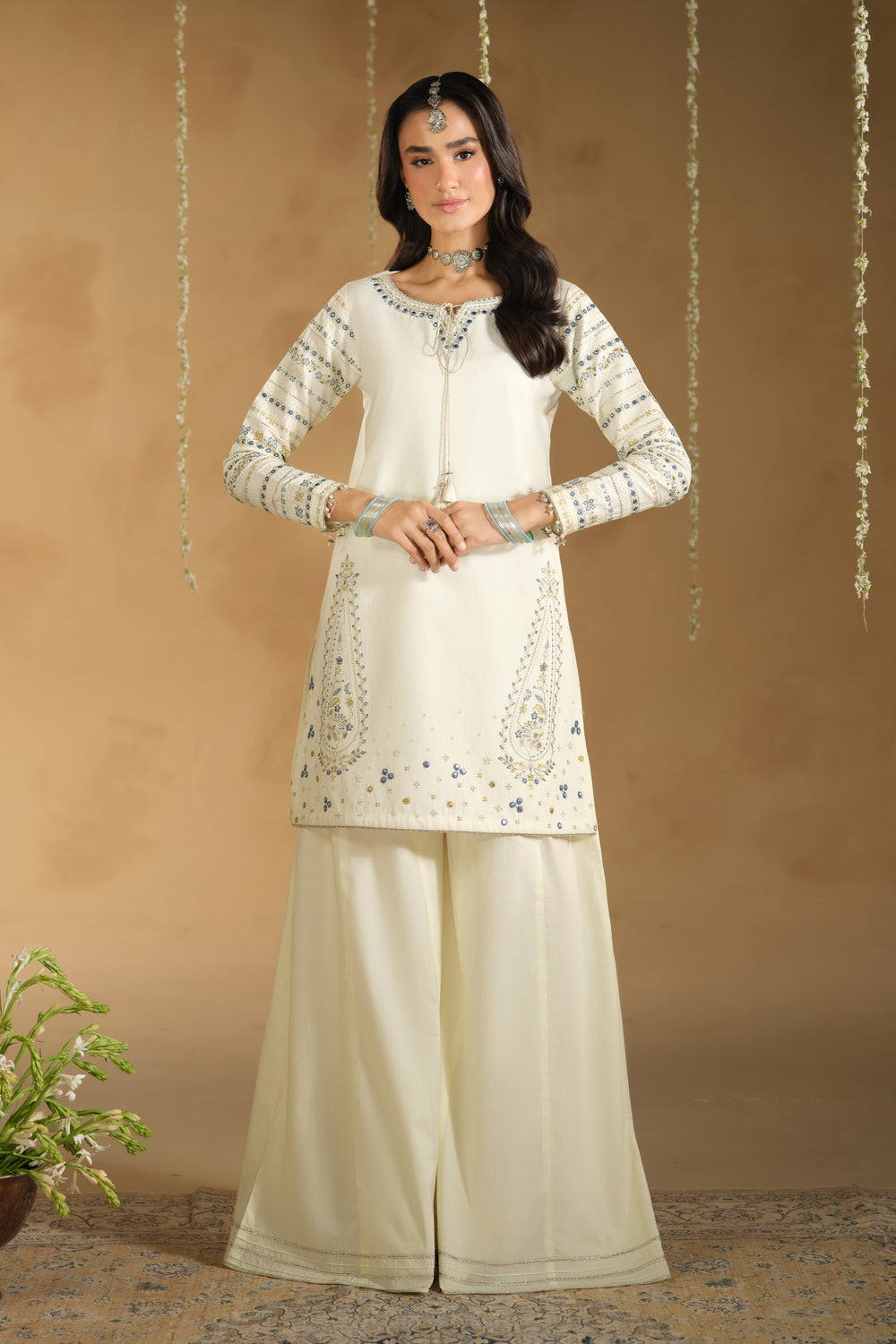 Full length view of Konain off white festive dress showing modest straight shirt silhouette and wide flary pants