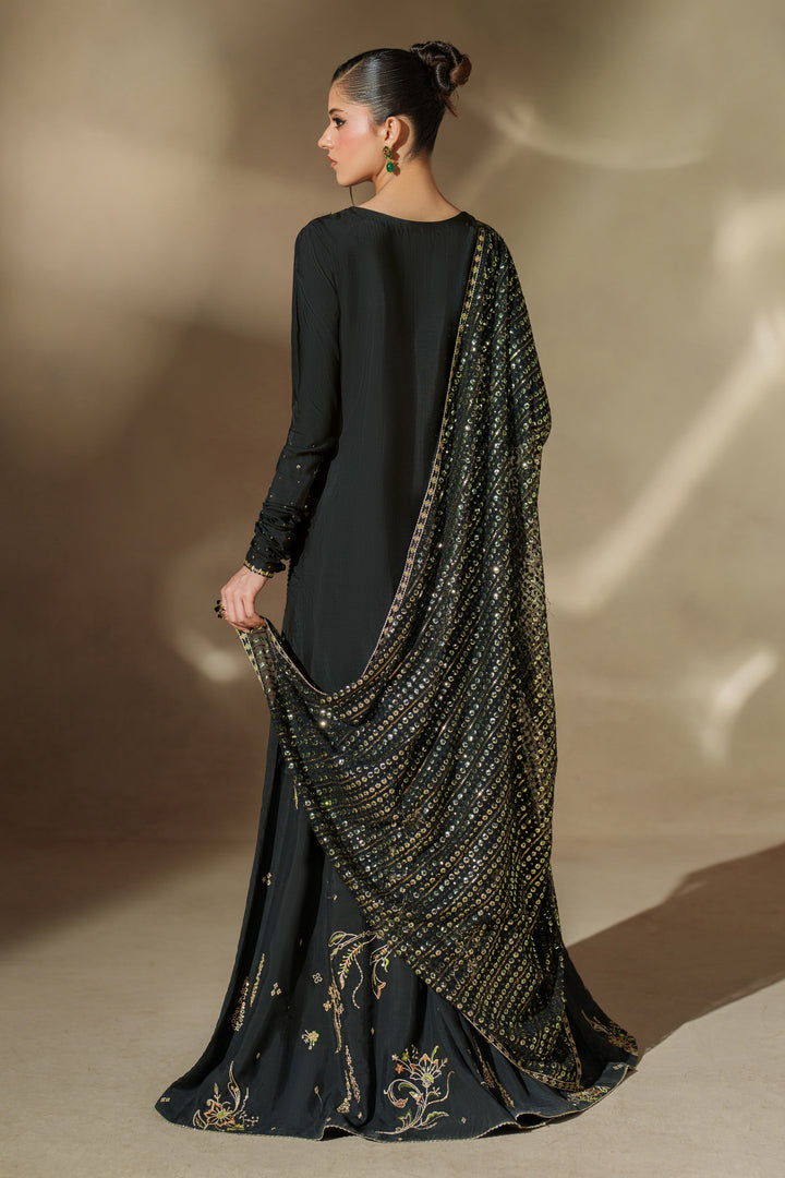 Side view of NAQSHI Misam black raw silk sharara set showing embroidered V-neck shirt, flowing sharara and matching net dupatta for festive events