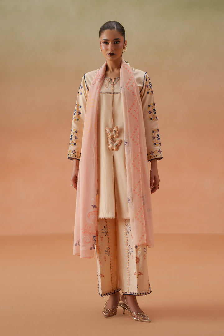 Model wearing Faye light peach embroidered lawn outfit with printed chiffon dupatta and cambric culotte trouser for festive daytime wear.