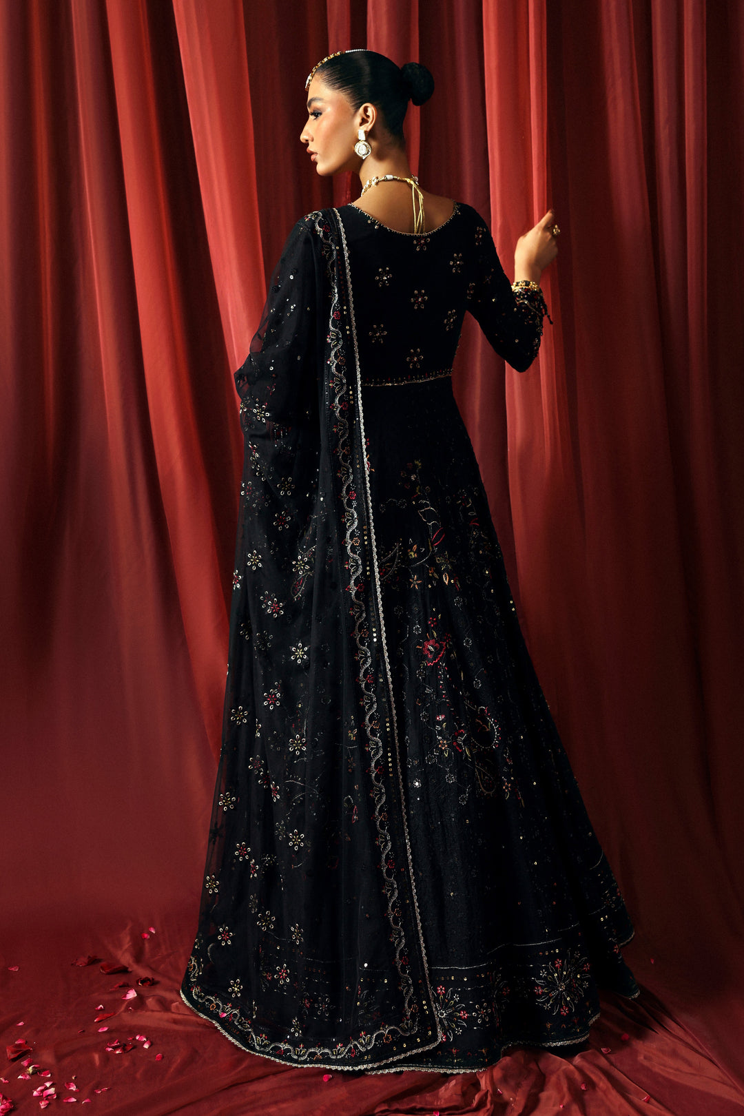back view of NAQSHI Mah Afroz black gown showing flowy panels, angled sleeves, and sequin embroidery detail