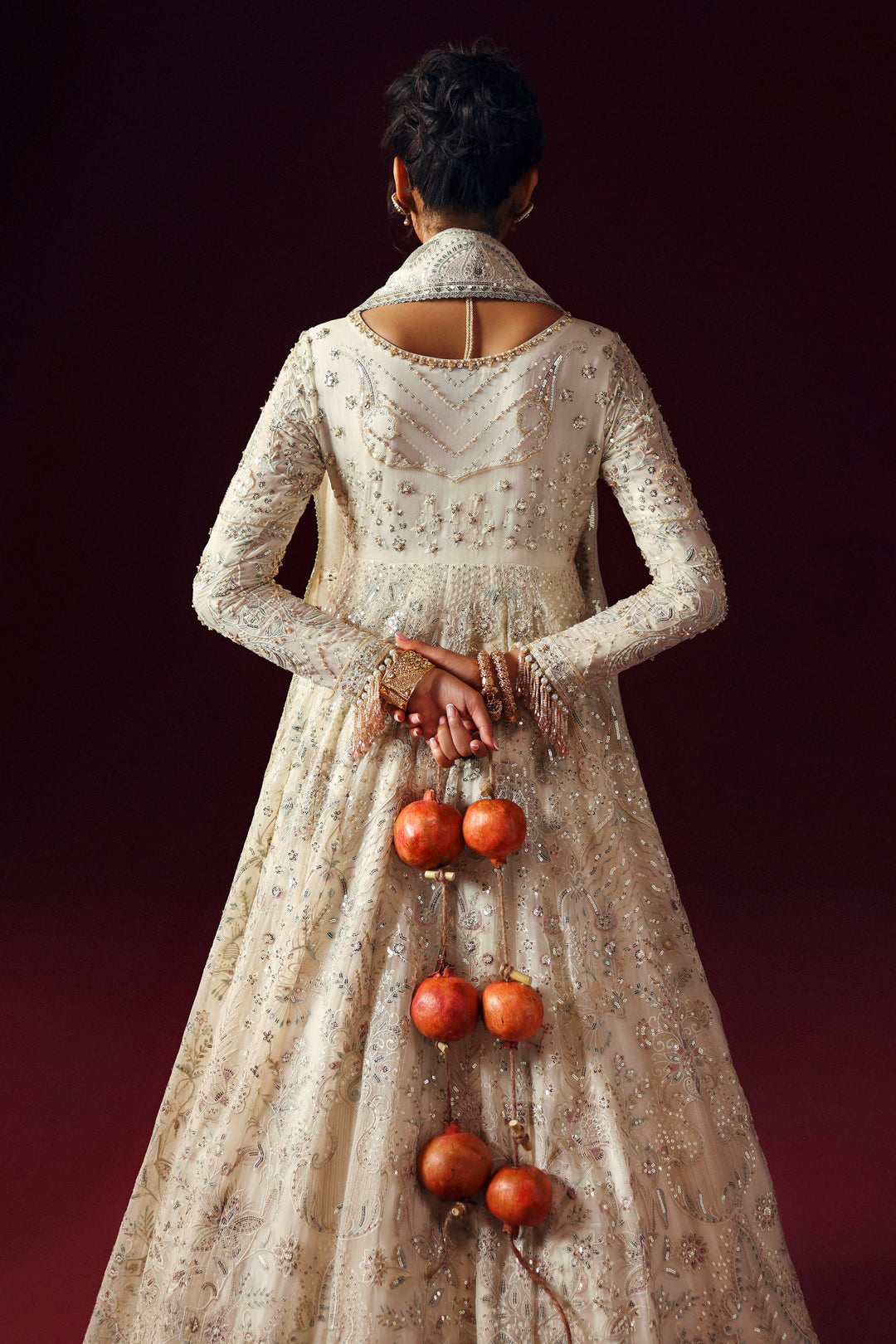 Side view of NAQSHI Nurzaad off‑white gown showing double‑flare panels and sequin embellishments