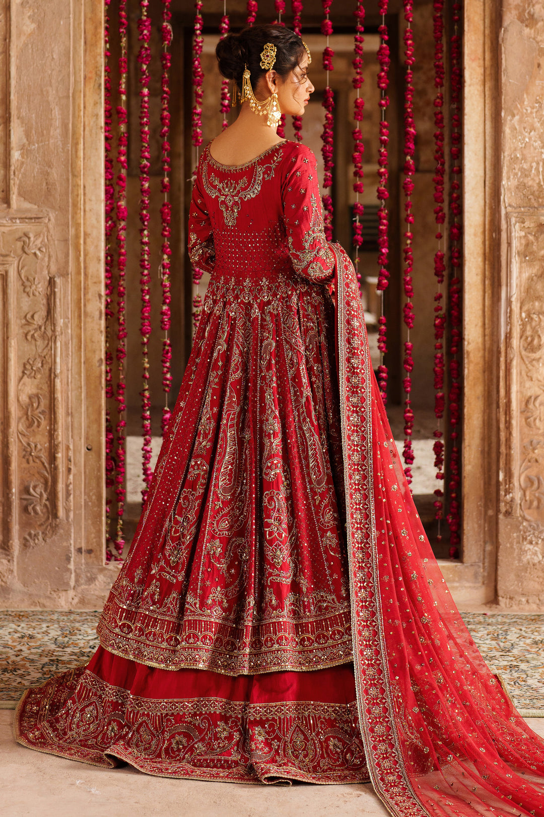 Back view details of NAQSHI Zeban red bridal lehenga with fine embroidered patterns and decorative stitching for formal wedding look.
