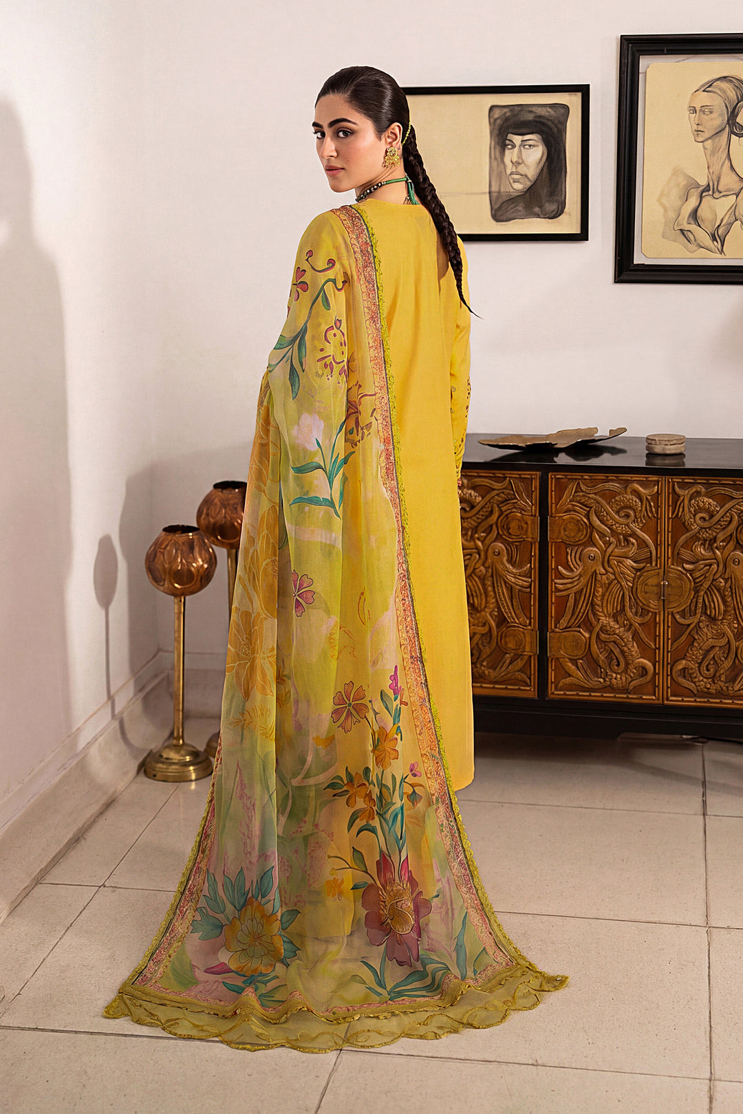 Side view of Seraya lemon embroidered lawn suit featuring floral embroidery, flared culottes and digitally printed tissue silk dupatta for summer occasions