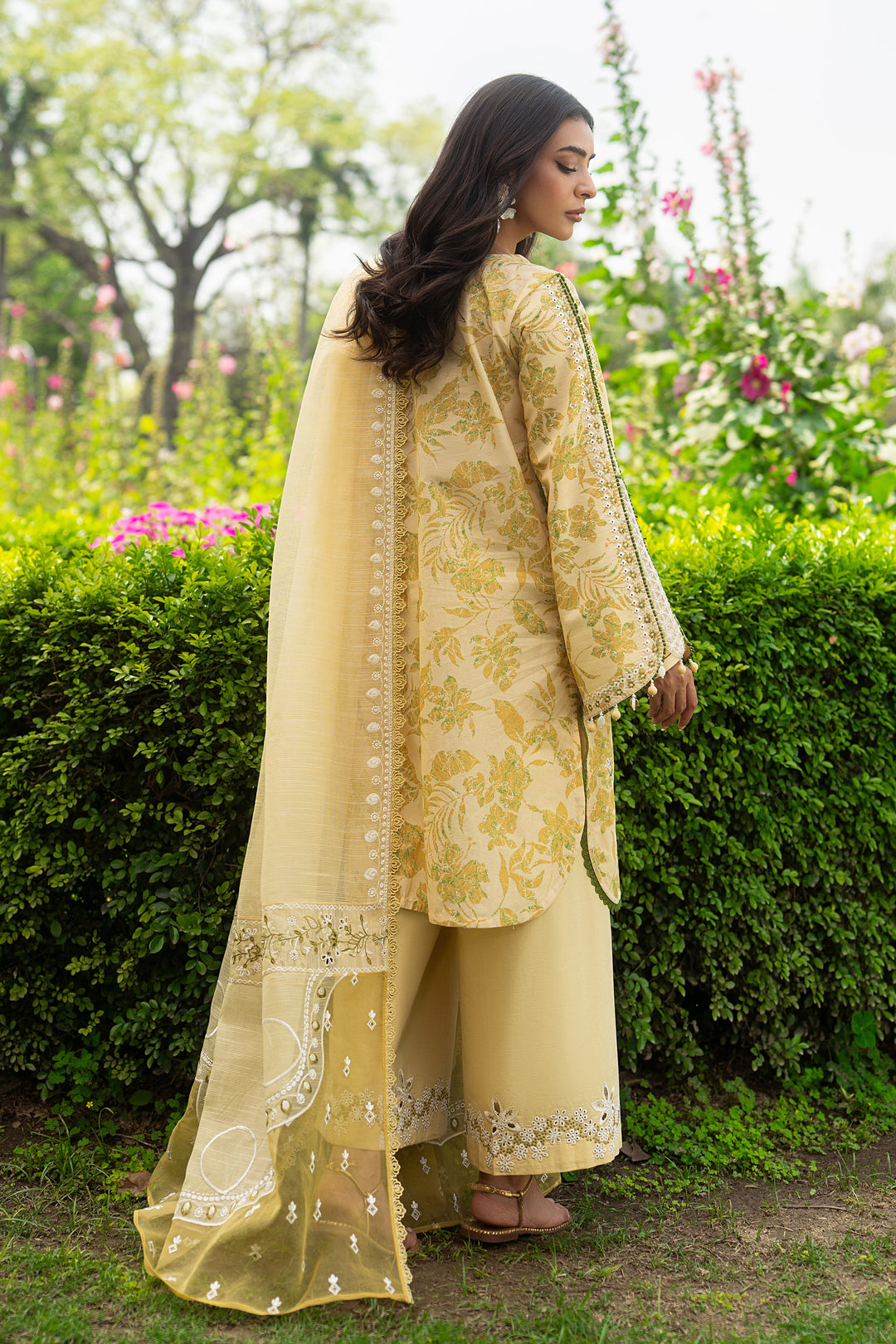 Back view of Ashfi yellow lawn shirt with loose straight cut and soft embroidered organza sleeves, paired with flared cambric trouser