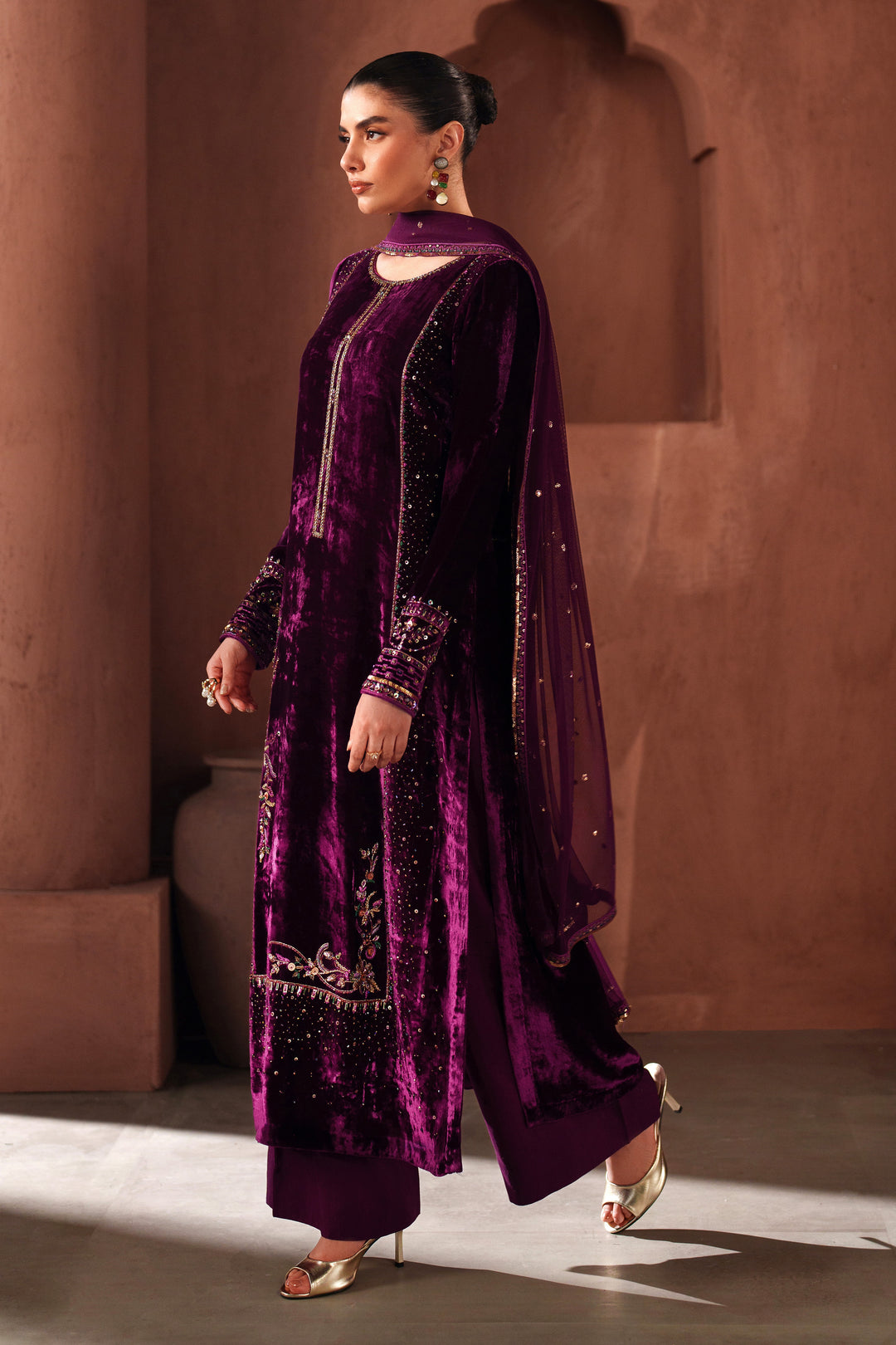 Full-length side view of NAQSHI purple velvet formal outfit showing flowing cut, detailed embroidery, and event-ready stitched finish