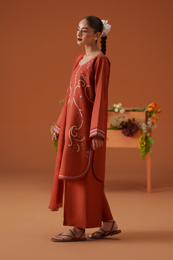 Side view of Ophelia rust ready-to-wear dress showing embroidered lawn shirt, wide culotte trouser, and soft printed dupatta.