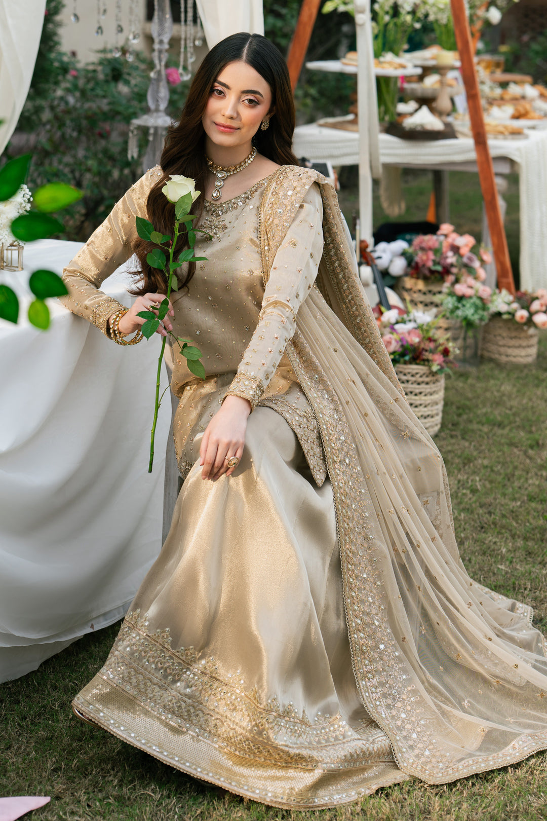 Side view of Orhaan dusty rose formal outfit showing flowing tissue sharara and light net dupatta.