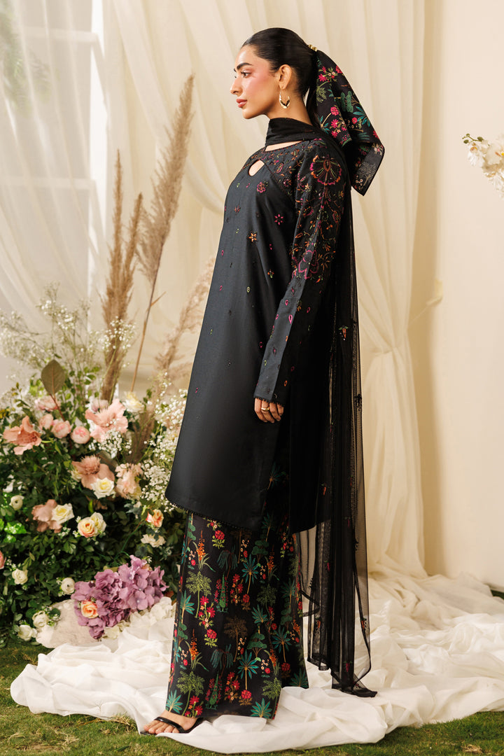 Side standing view of NAQSHI Halia outfit showing flowing black shirt, soft embroidery, and relaxed casual look