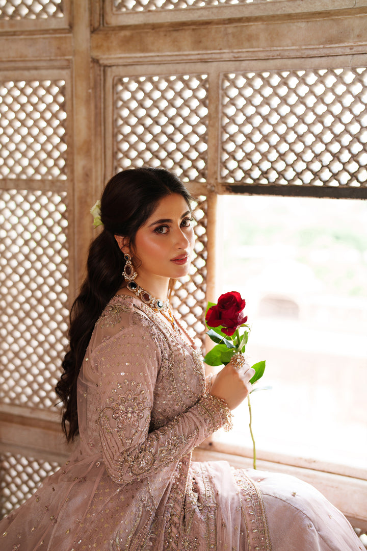 Portrait of NAQSHI Mareeha soft pink formal gown worn with elegant jewelry showing fine embroidered detail for wedding celebrations.