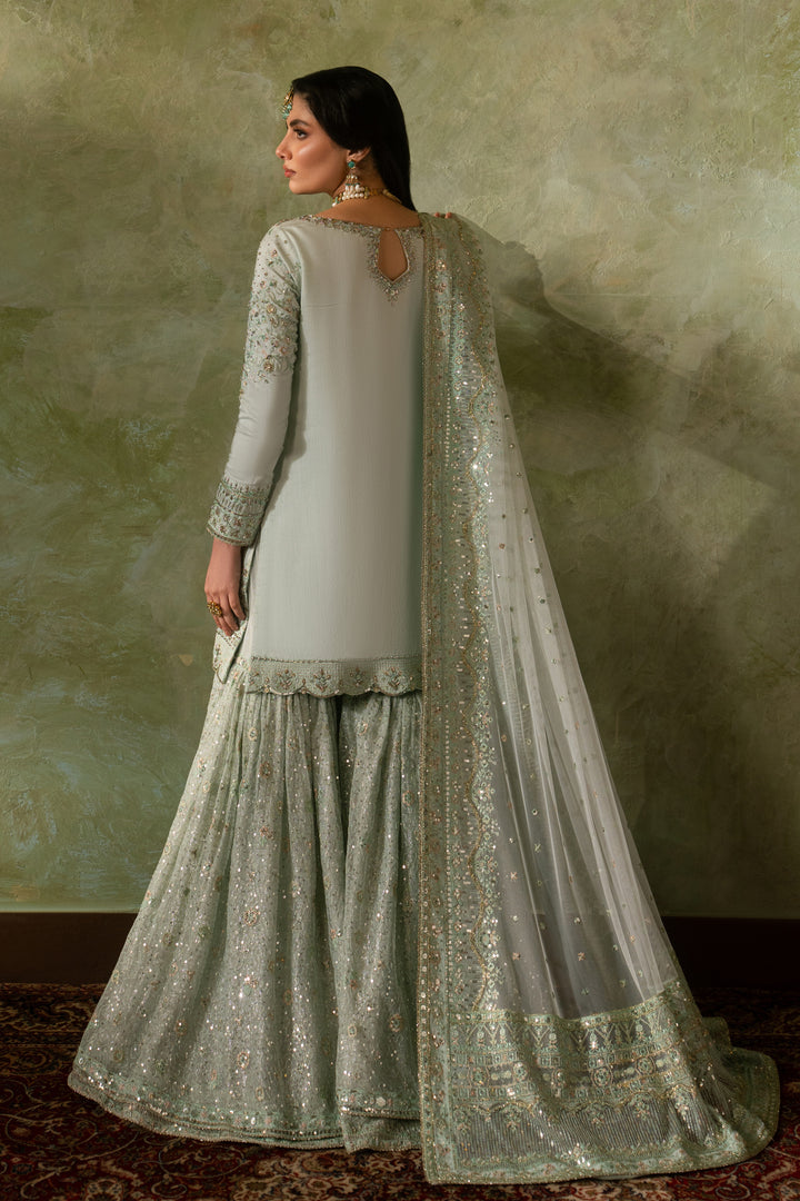 Back view of Azeyma pistachio formal Nikkah outfit showing full sharara flare and bordered net dupatta drape, complete ready to wear bridal attire.