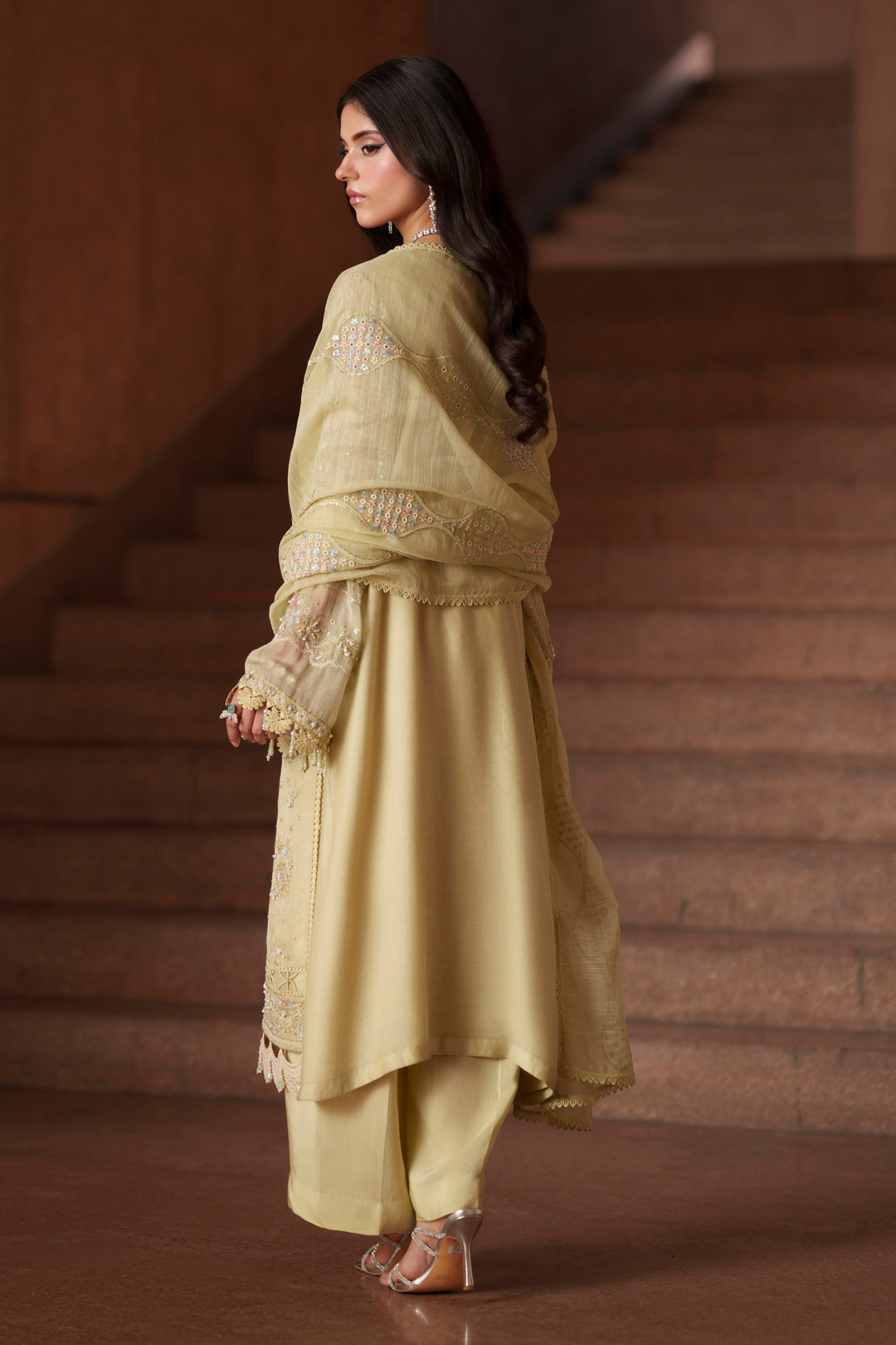 Side profile of NAQSHI Luzia light lime luxury pret outfit showcasing graceful movement, embroidered detailing and modern Eastern styling