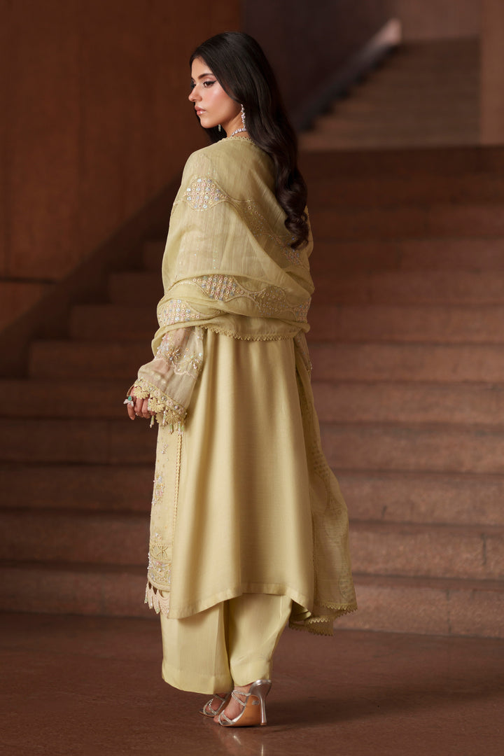 Side profile of NAQSHI Luzia light lime luxury pret outfit showcasing graceful movement, embroidered detailing and modern Eastern styling