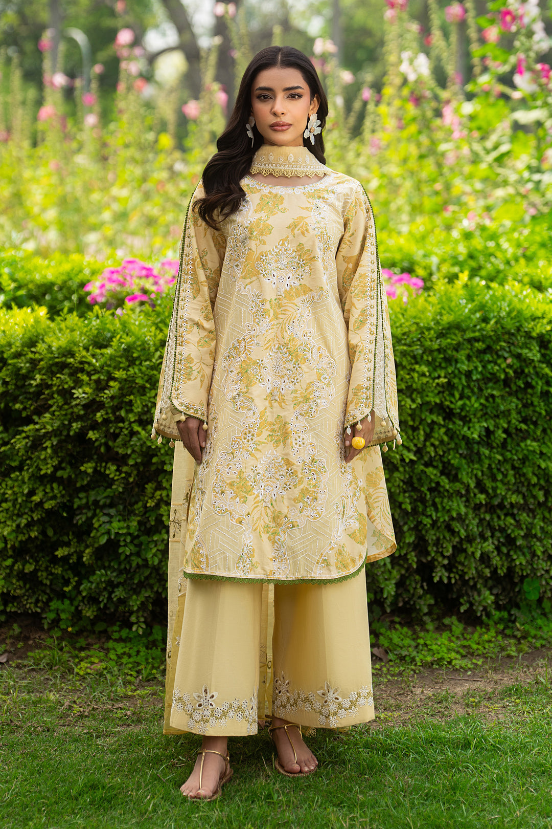 Front full look of Ashfi yellow embroidered lawn outfit showing neat vertical white thread work and relaxed summer fit.