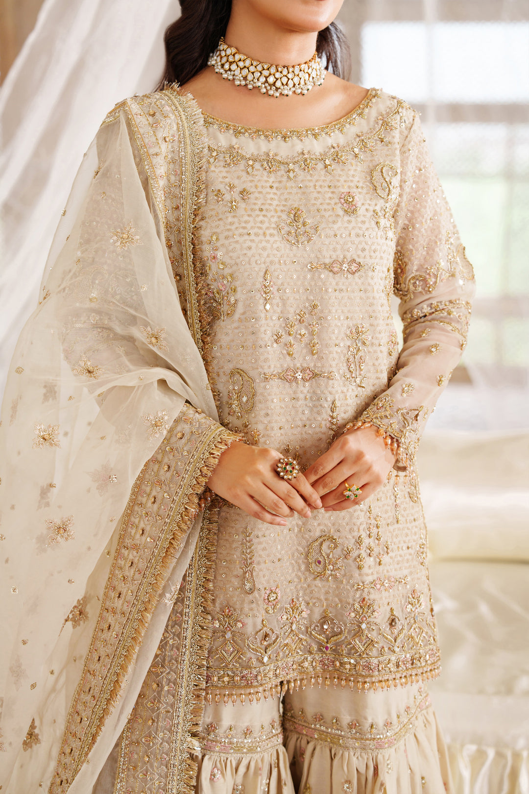 Close up front detail of NAQSHI Aneeqa ivory beige formal dress showing intricate embroidery and textured design for wedding celebrations.