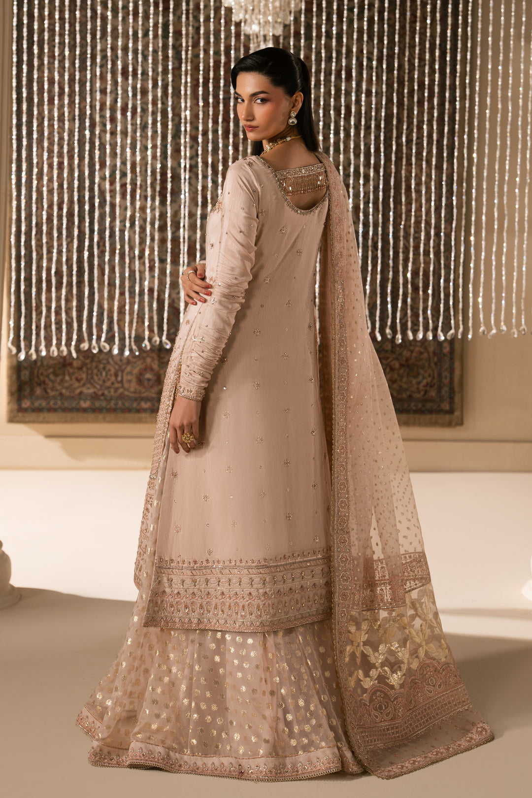 Side view of Mahbeer pale pink Nikkah dress showing smooth shirt fall, flared sharara and soft organza dupatta drape, elegant ready made bridal formal outfit.