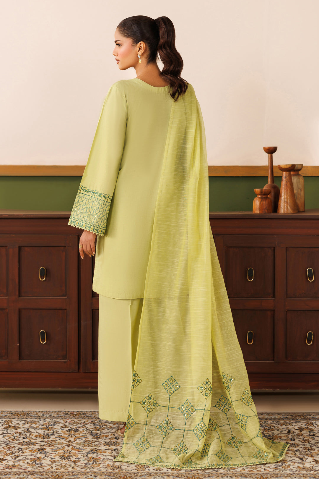 Back view of NAQSHI light green cambric outfit showing relaxed shirt fall, loose sleeves, and soft embroidered dupatta