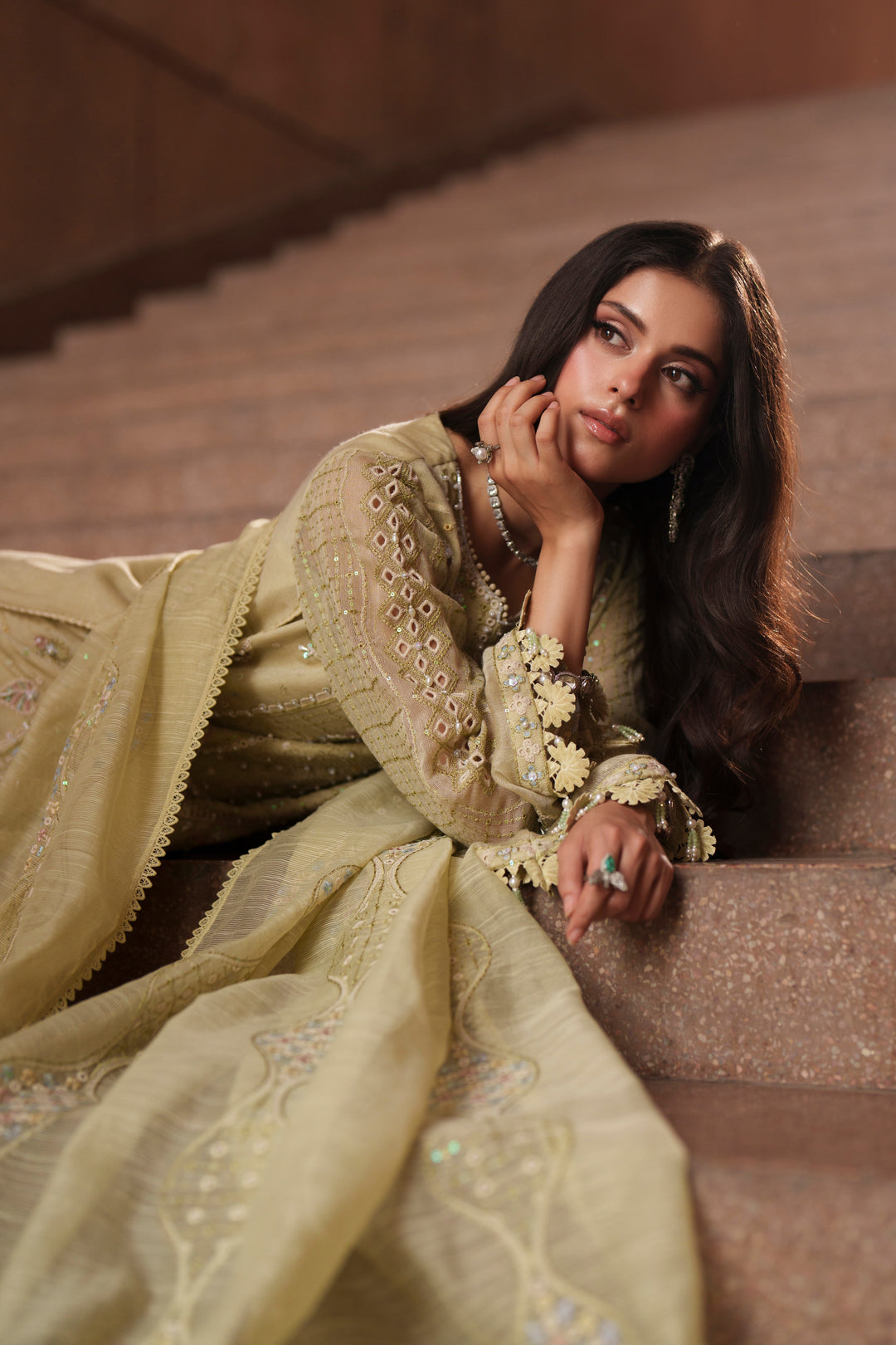 Seated styling shot of Luzia light lime embroidered evening wear outfit highlighting intricate embroidery, relaxed silhouette and refined craftsmanship