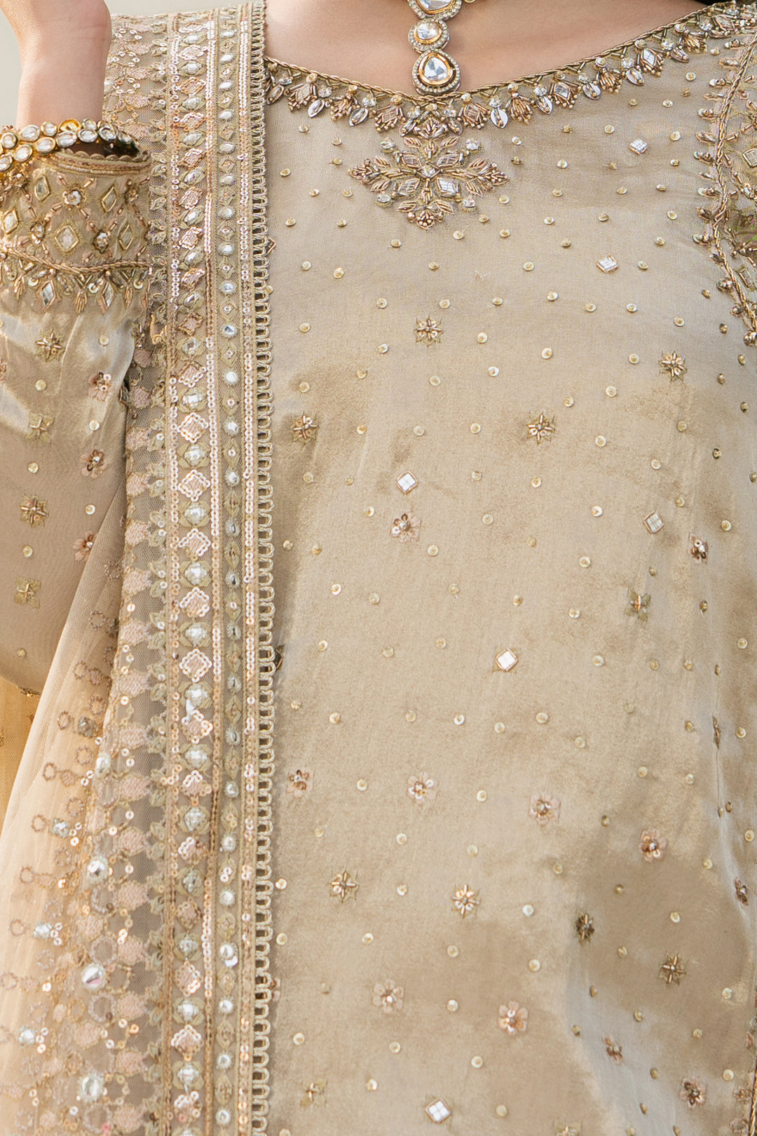 Close-up of embroidery, sequin, and sheet work on Orhaan dusty rose tissue shirt, fine formal detailing
