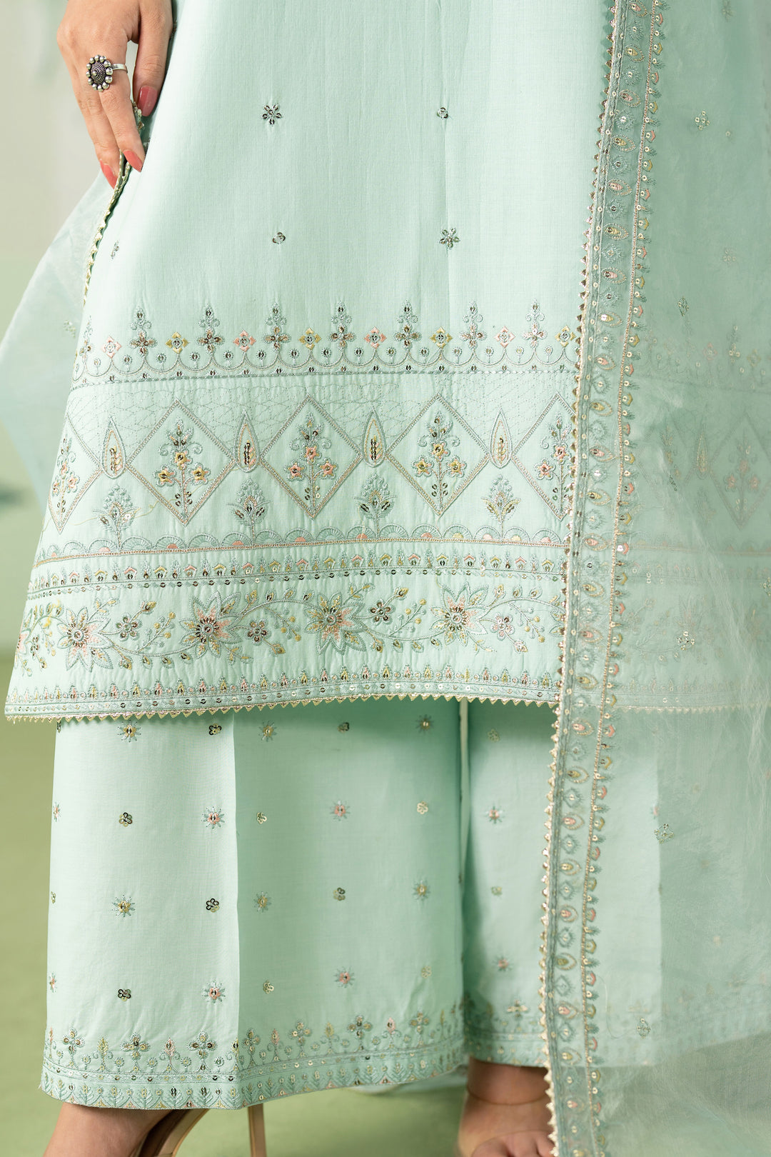 Detailed close up of heavily embroidered shirt border and trouser hem on Taabu aqua ready to wear suit