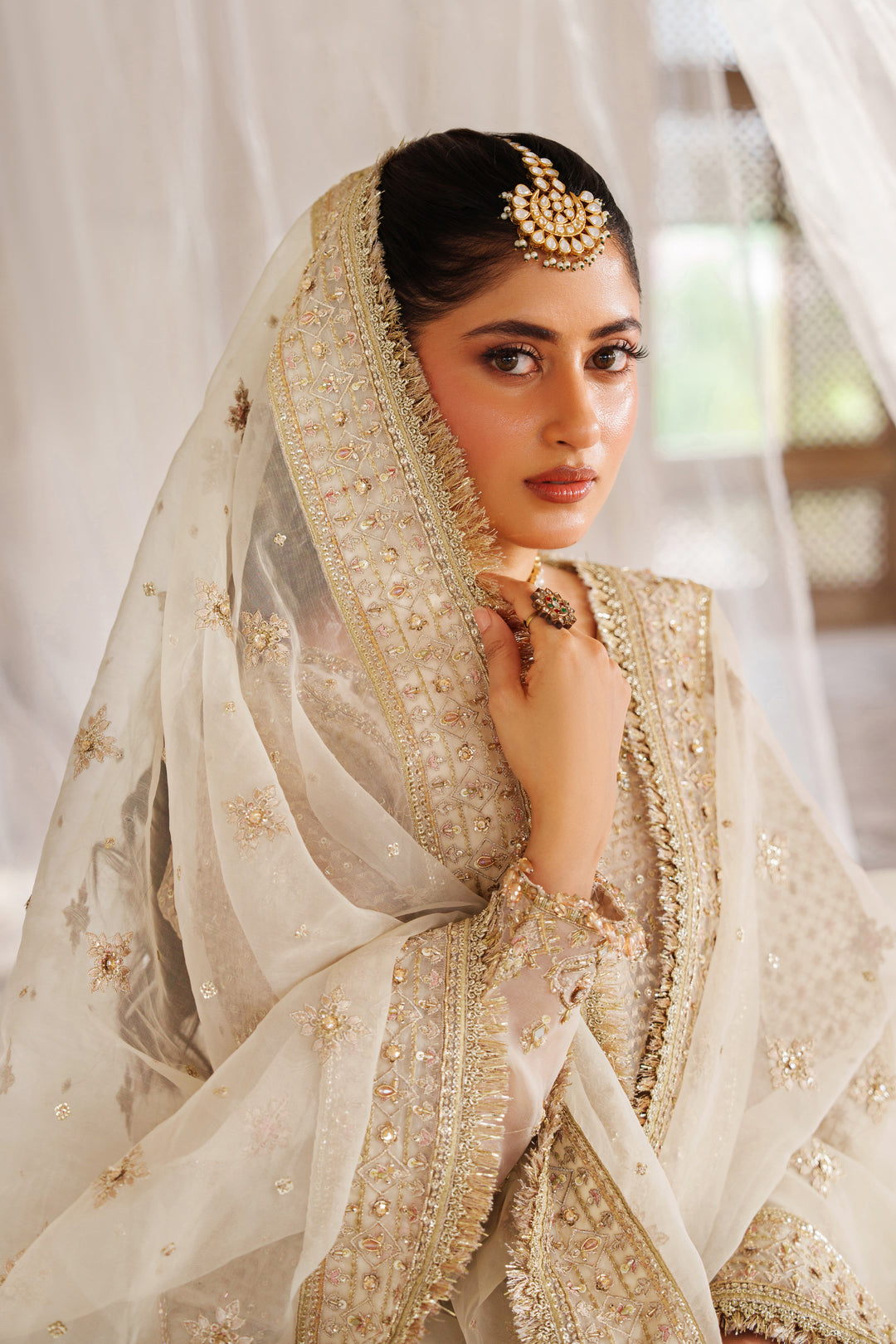 Portrait style close up of NAQSHI Aneeqa ivory beige ready-to-wear dress with embellished neckline and detailed embroidery for event outfits.