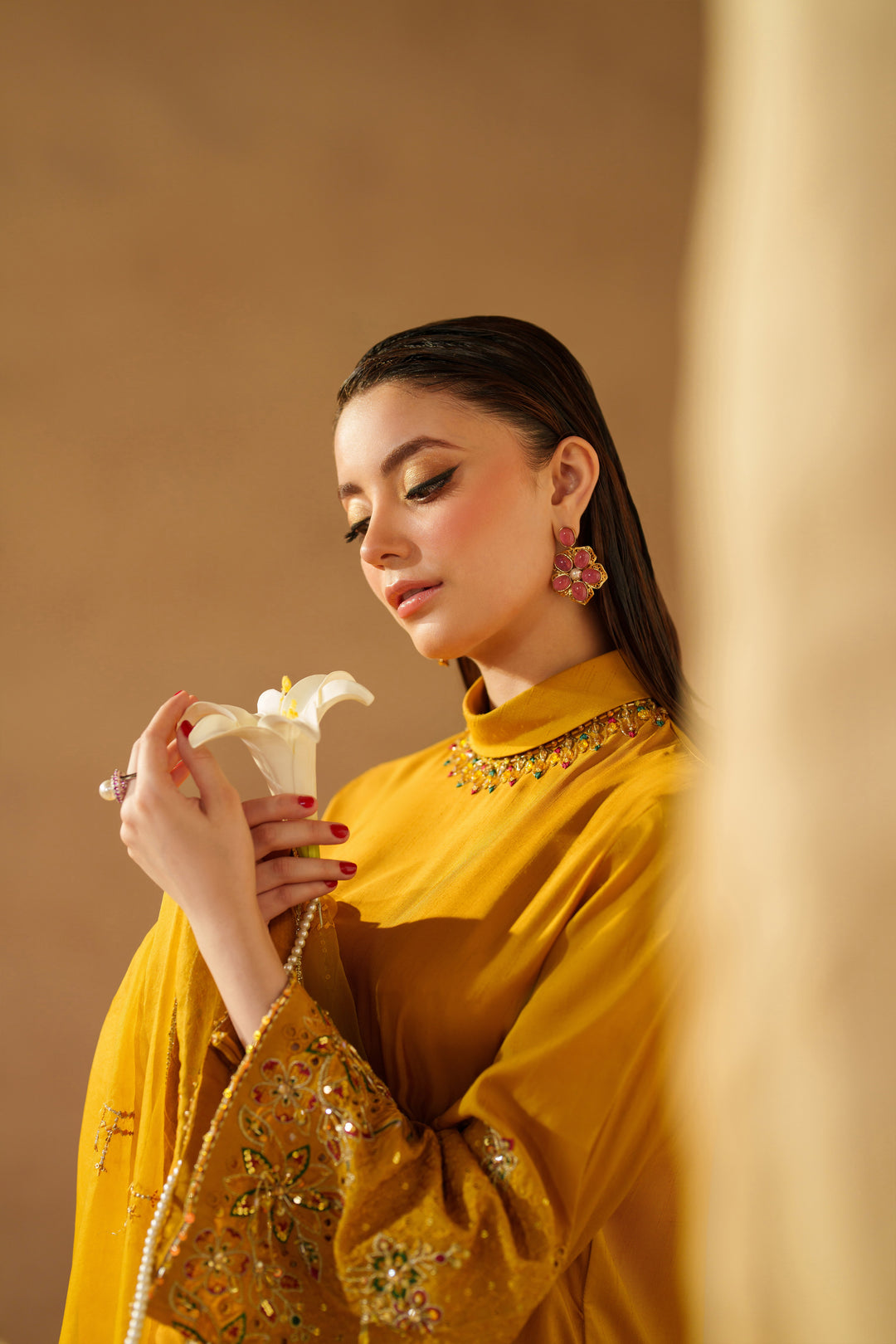 Portrait of model wearing NAQSHI Marlyin mustard yellow luxury pret dress showing neckline, embroidery detail, and ready-to-wear elegance
