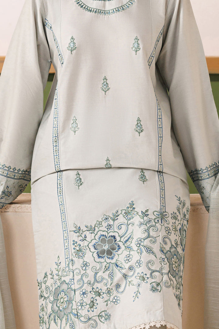 Close-up of NAQSHI Piper cambric shirt showing spread embroidery motifs and floral organza patch detail on the hem