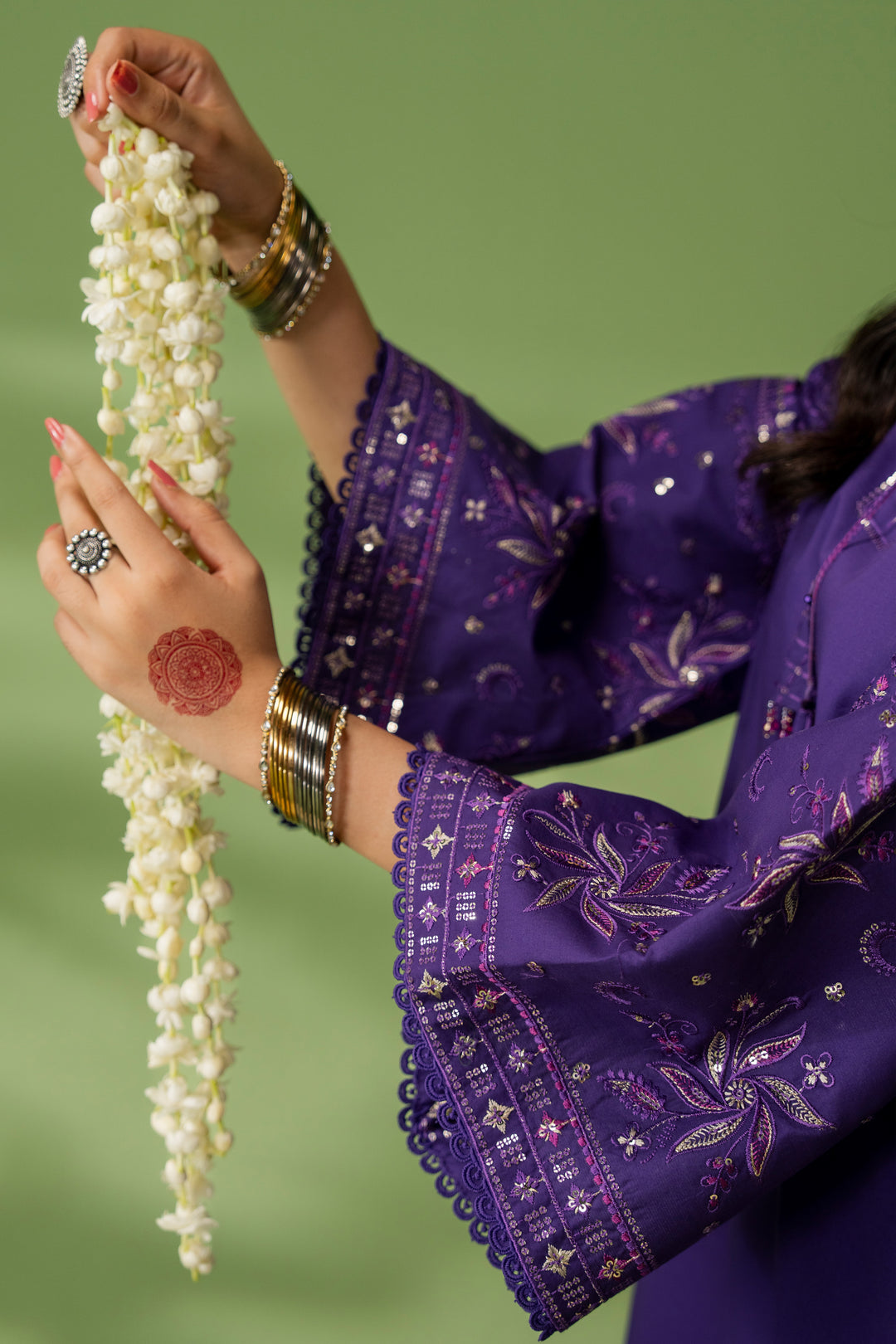 Close-up of NAQSHI Uzma sleeve showing full embroidery detail on purple fabric