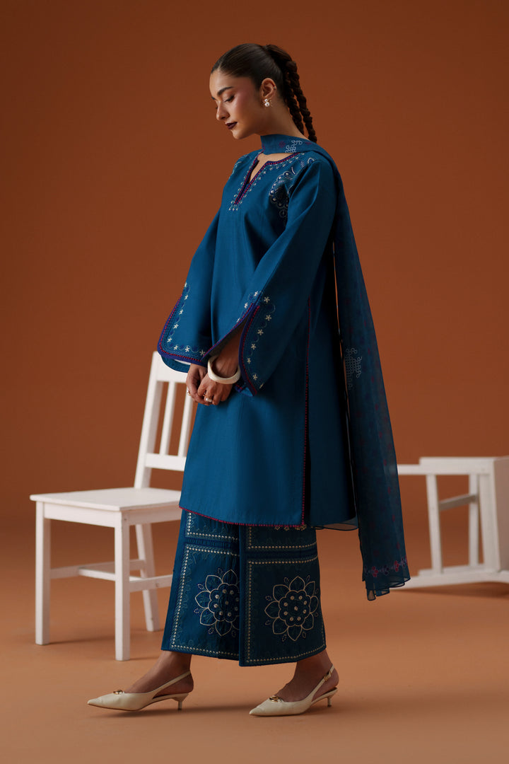 Side view of Juni teal 3-piece outfit with loose lawn shirt, embroidered culotte trouser, and soft printed chiffon dupatta.